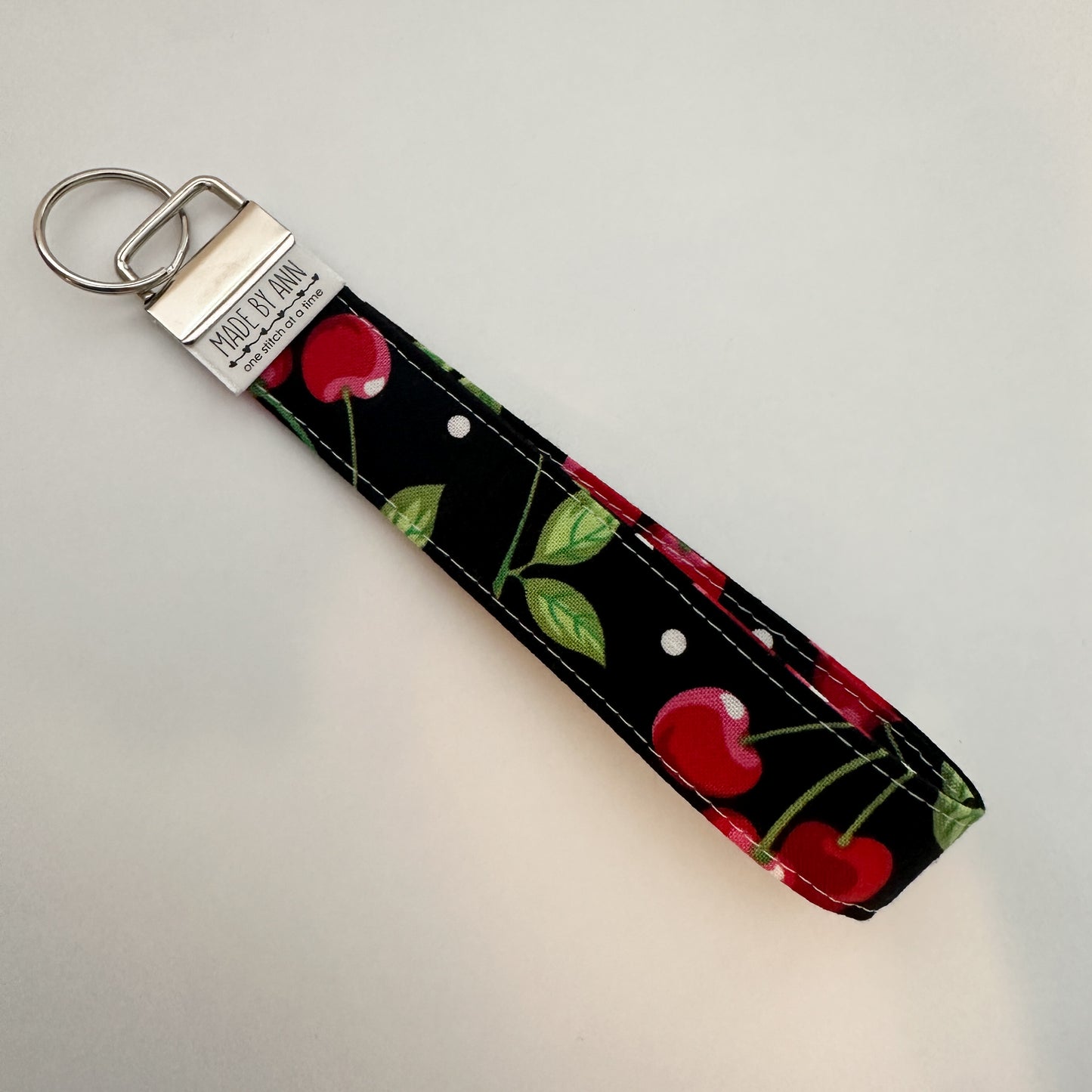 Keychain with cherry design on a black background