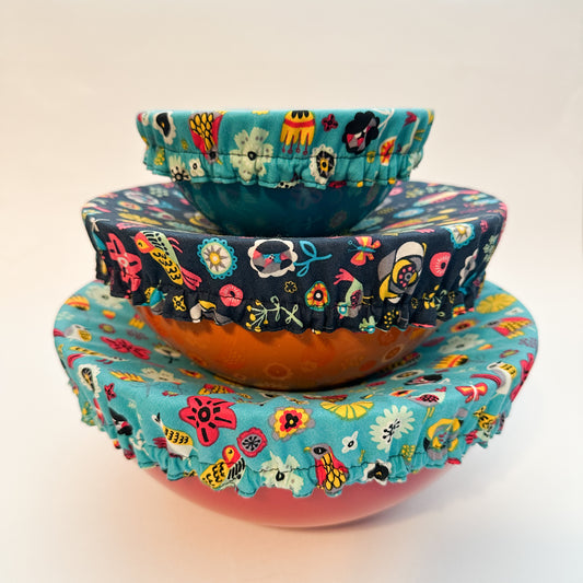 Stack of colorful fabric-covered bowls on a light background