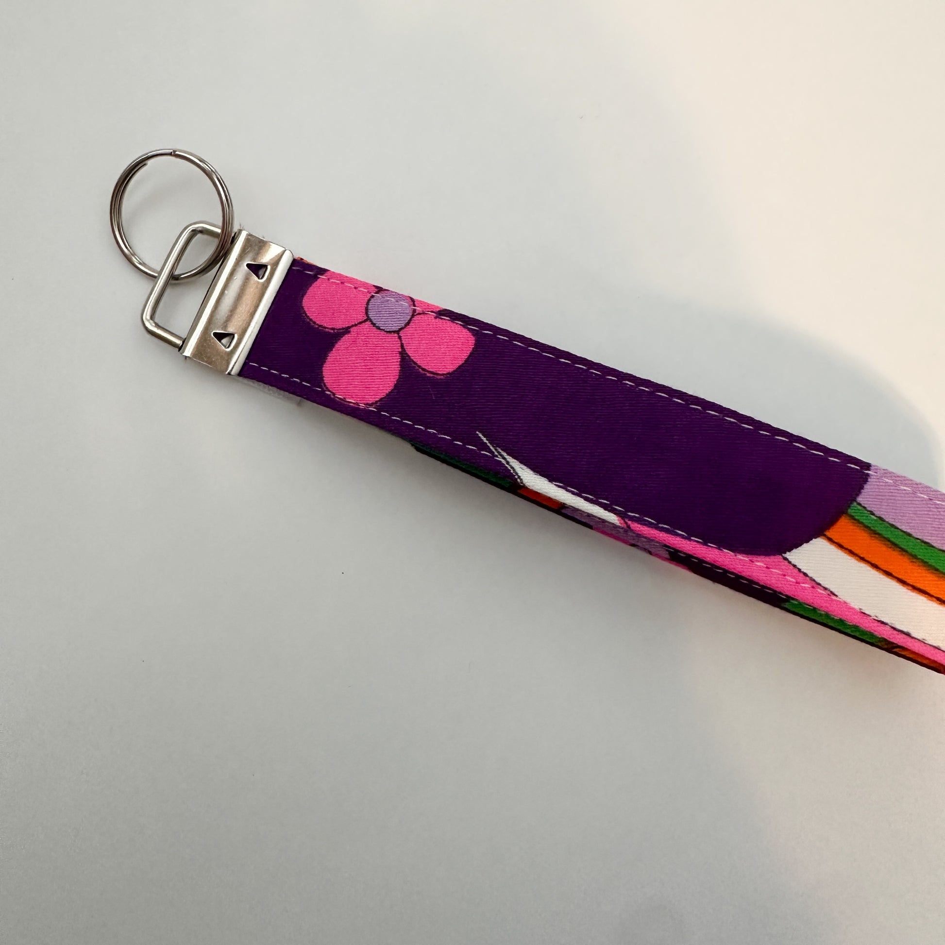 Keychain with pink floral design on a purple strap