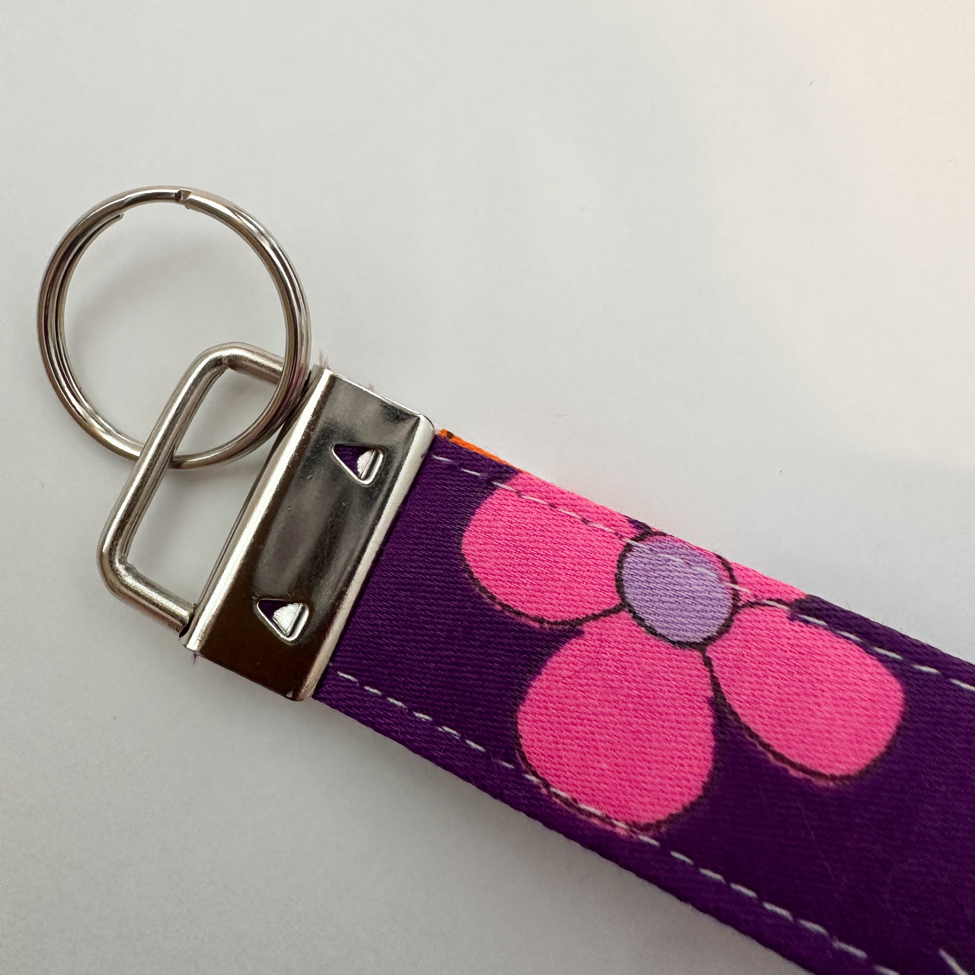 Keychain with pink floral design on a purple strap